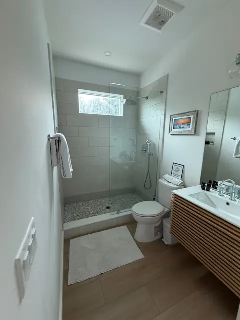 Bathroom with a glass shower, clean vanity and neatly arranged towels
