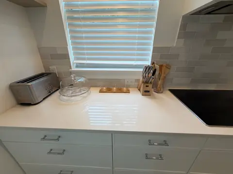 Kitchen countertop with neatly arranged glassware, utensils and a toaster